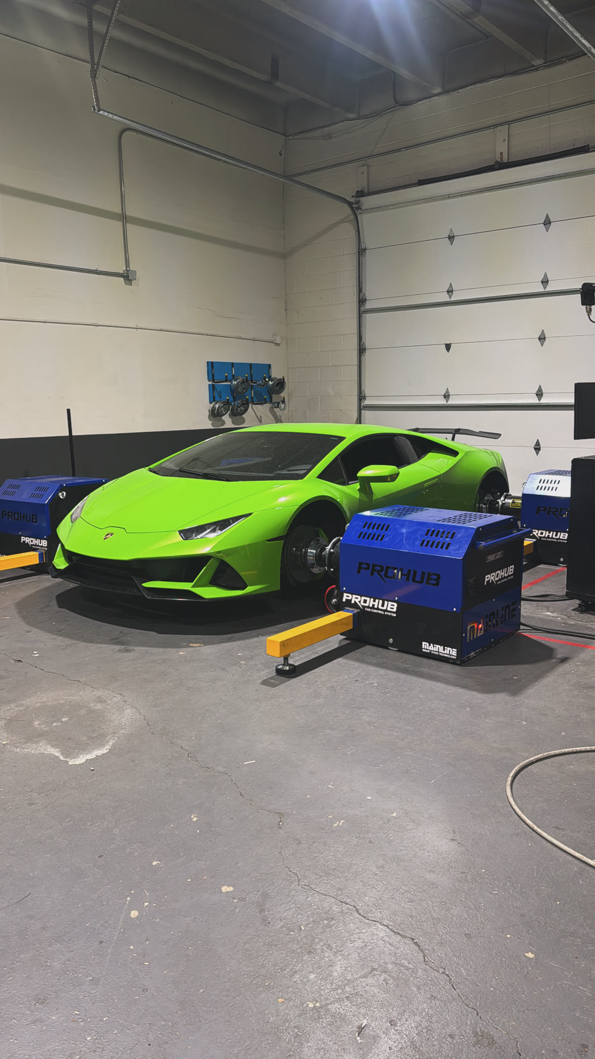 Green Lamborghini Huracán strapped to the Mainline ProHub hub dyno in the PME shop